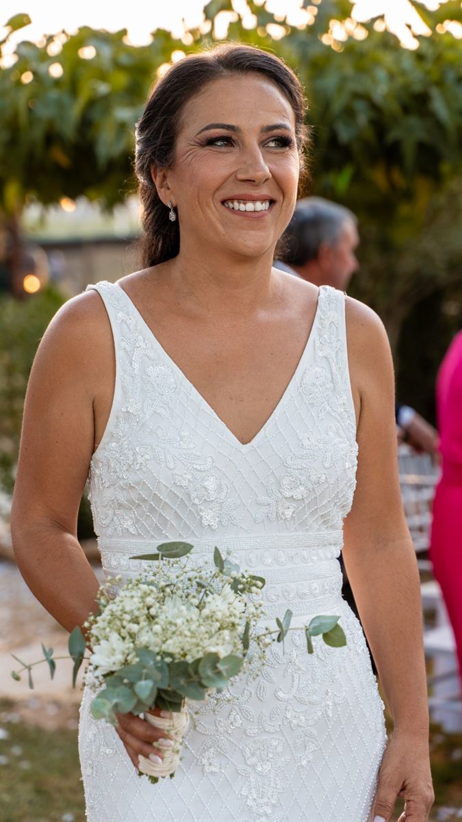 Novia sonriendo con ramo de flores blancas en una boda al aire libre en Málaga