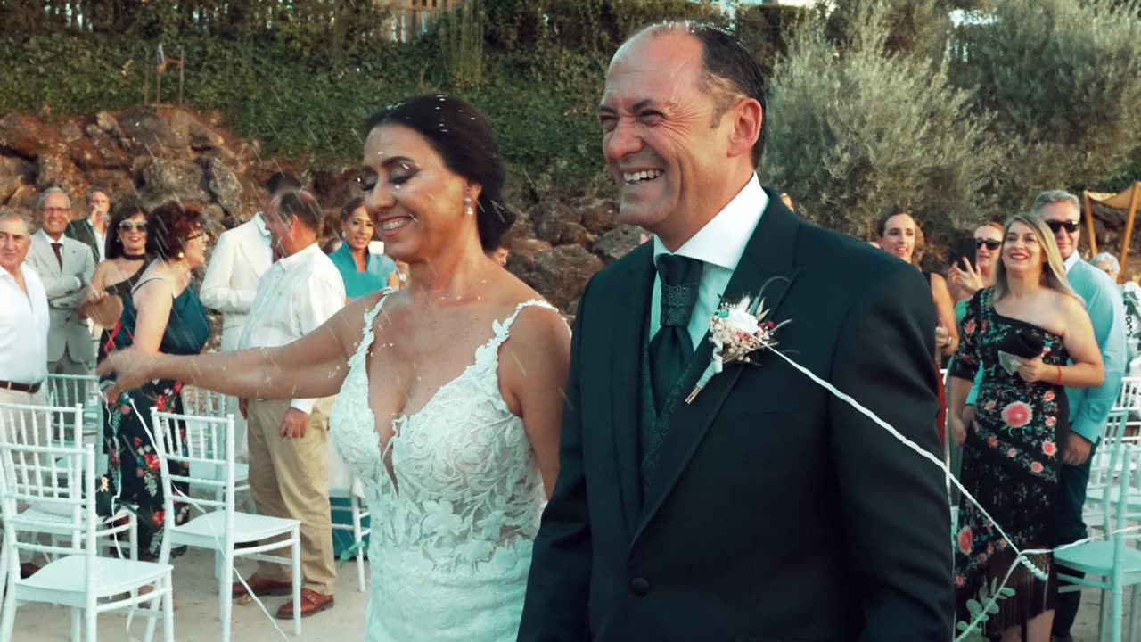 Novios sonriendo entre los invitados al salir de la ceremonia
